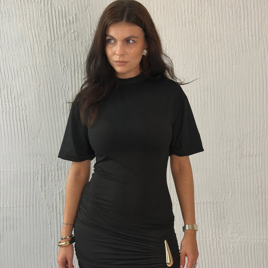 Modelka prezentująca czarną sukienkę LUMI w ruchu